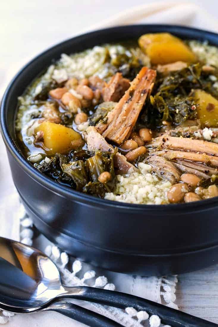 Slow Cooker Italian Pork Stew in a black bowl with parmesan cheese