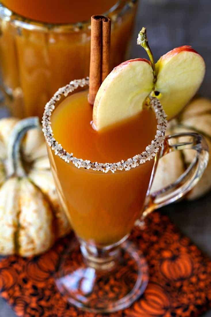 slow cooker apple cider cocktail with a sugared rim