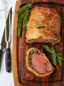beef wellington with a slice on a board