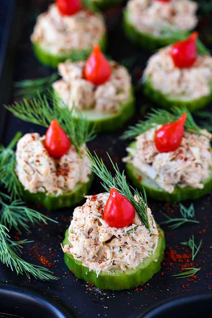 crab salad appetizers on a black platter with fresh dill