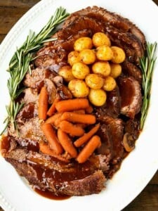 Pot roast recipe on a platter with vegetables is a perfect sunday dinner