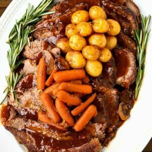 Pot roast recipe on a platter with vegetables is a perfect sunday dinner