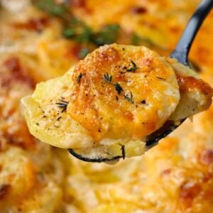scalloped potatoes with a spoon of cheesy potatoes