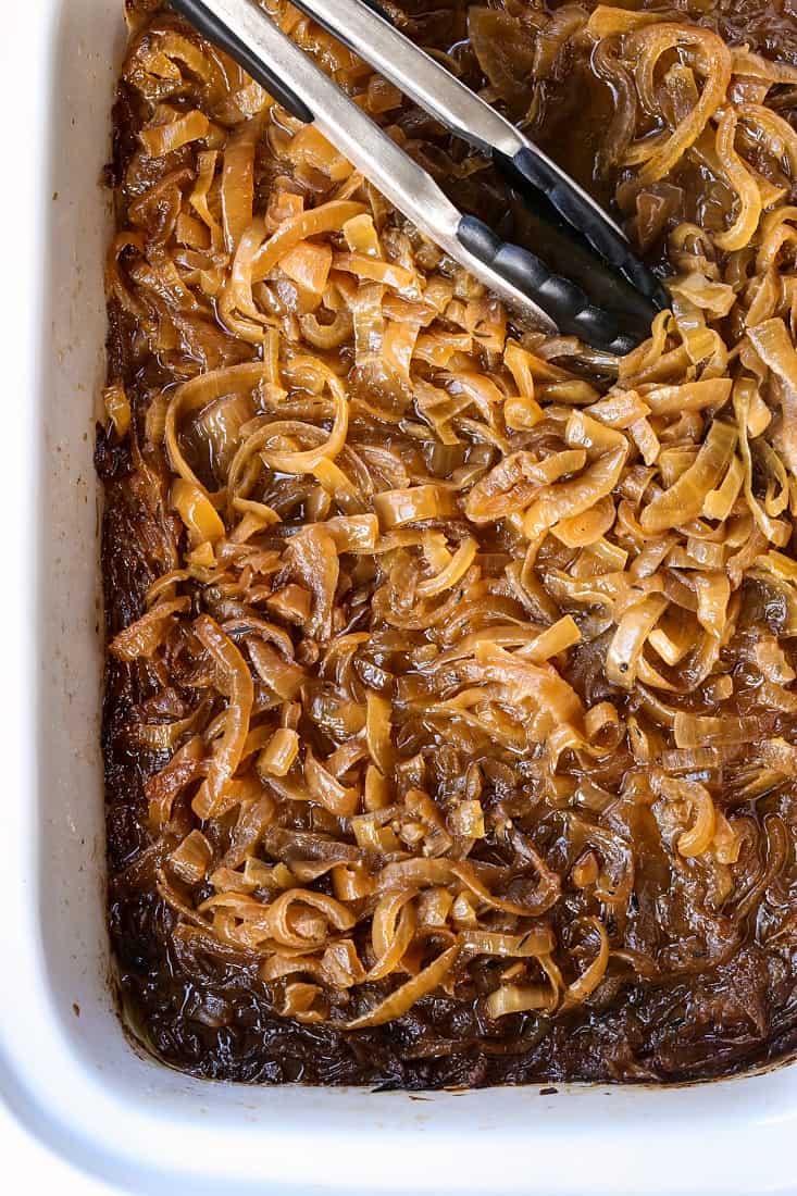 Caramelized Onions in a slow cooker with tongs