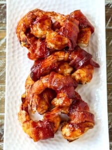 bacon wrapped shrimp on a white platter
