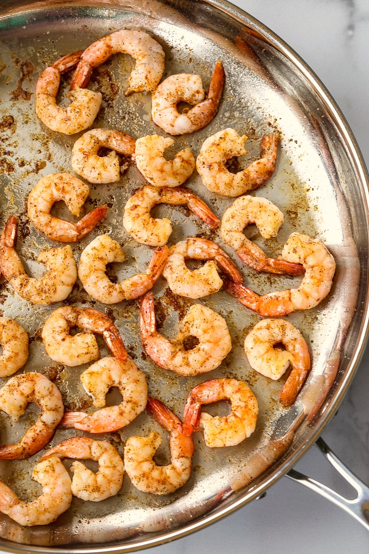 shrimp in a skillet on a marble board
