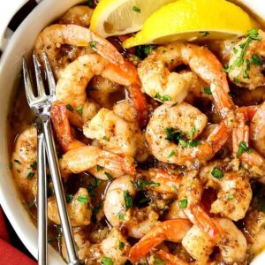 garlic butter shrimp in a white crock with forks