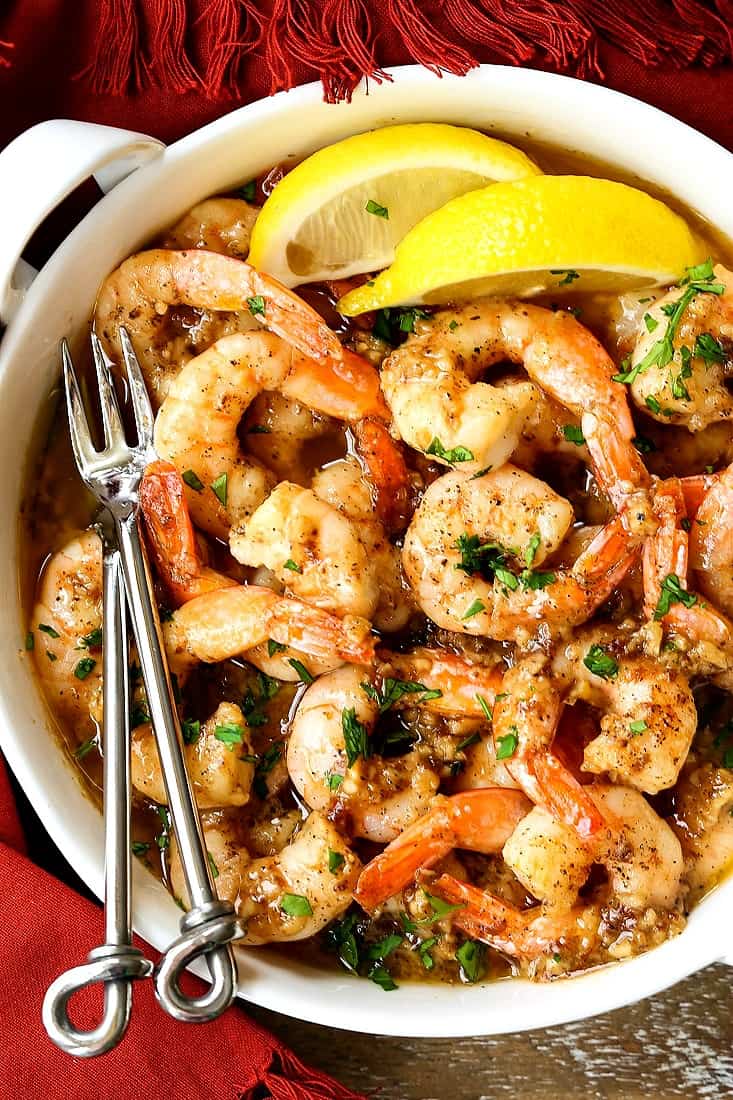 garlic butter shrimp in a white crock with forks