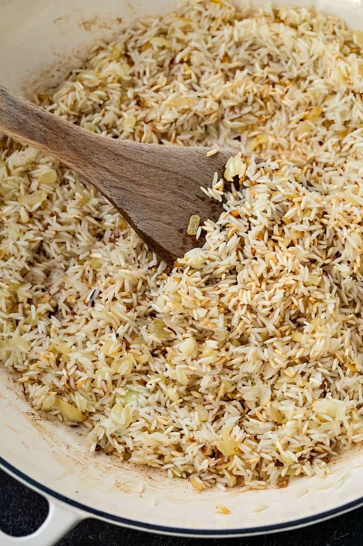 Spanish Rice recipe being browned in butter and onion