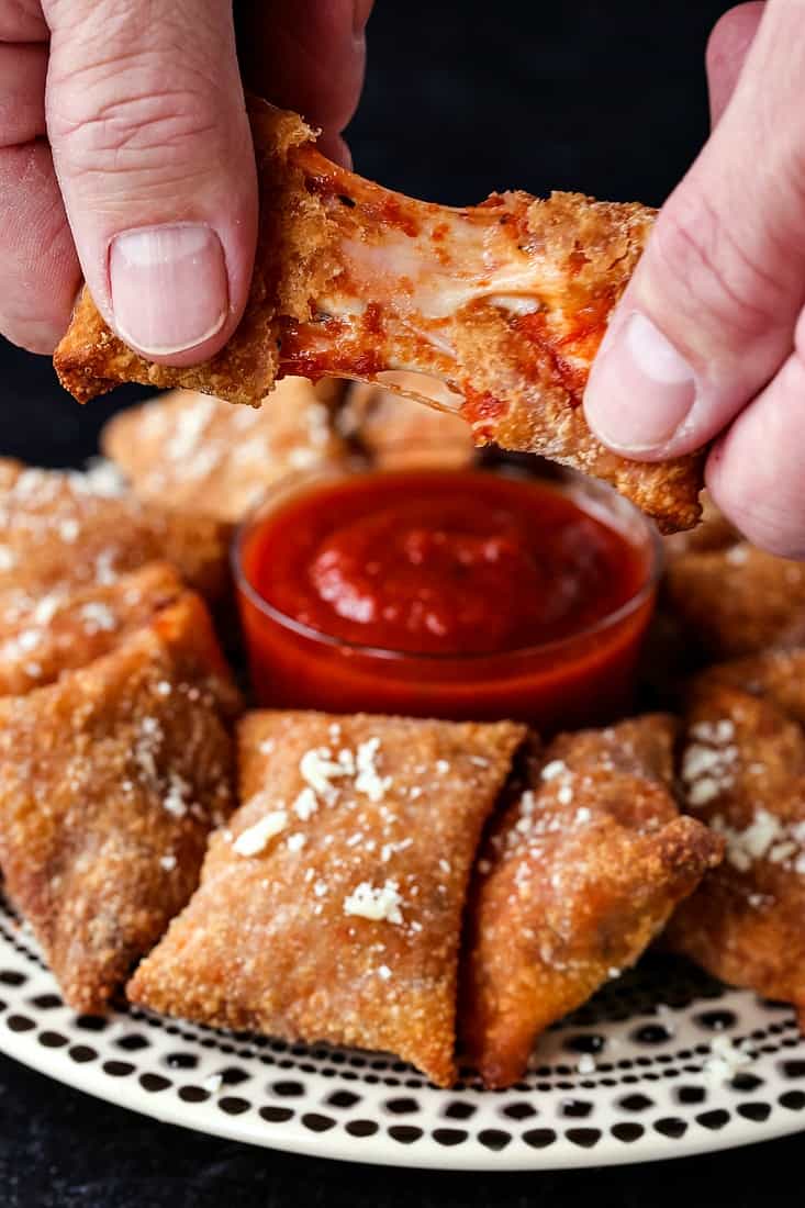 A cheese pizza roll being pulled apart to show the stretchy, gooey mozzarella.