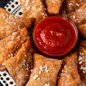 Copycat Totino's Pizza Rolls on a plate with tomato sauce for dipping.