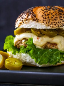 Turkey burger recipe with lettuce, cheese and jalapeños on a poppy seed bun