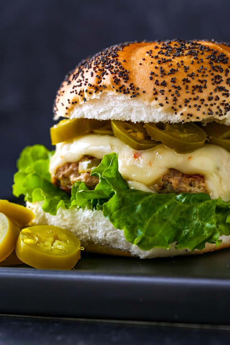 kalkoenburgerrecept met sla, kaas en jalapeños op een maanzaadbroodje