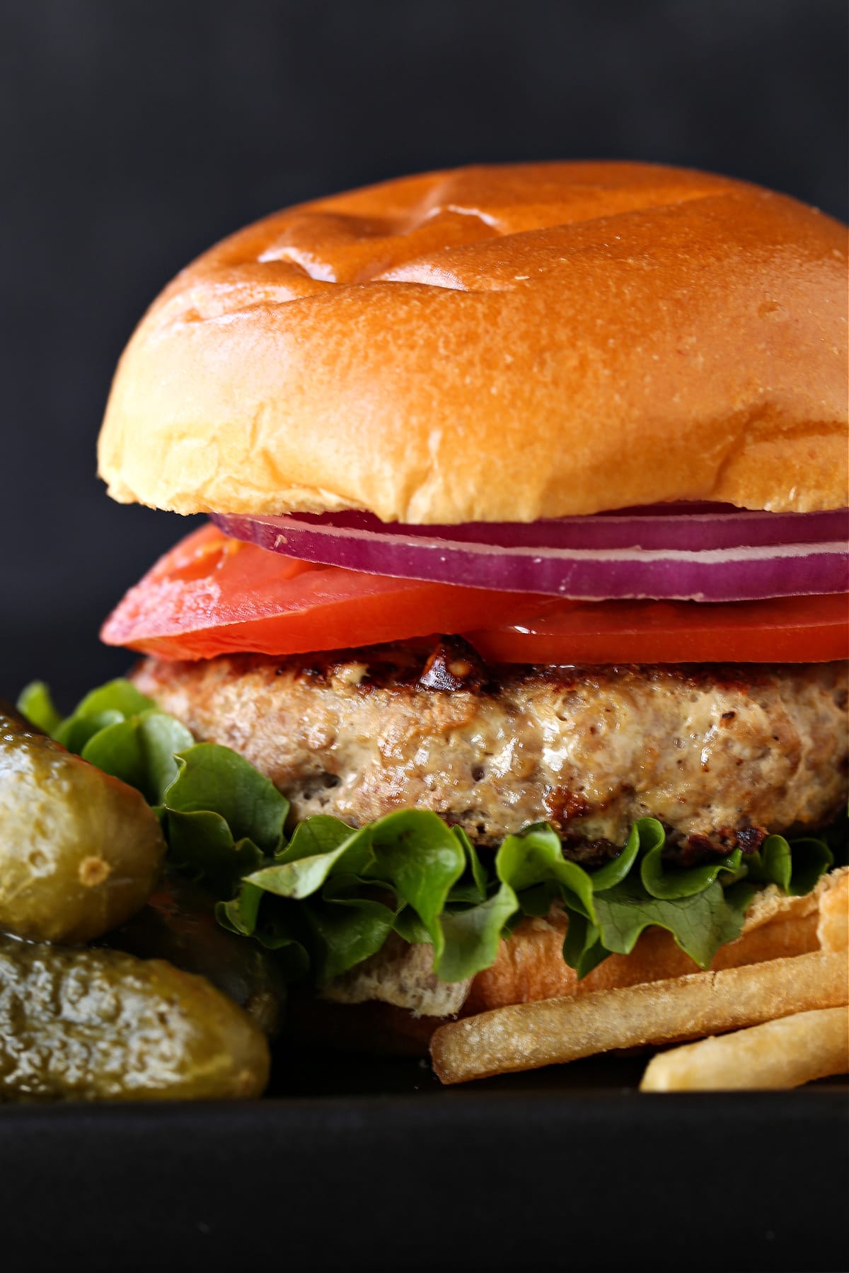 turkey burger on a bin with lettuce, tomato slices and red onion