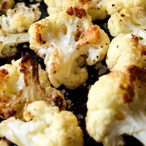 roasted cauliflower with parmesan cheese on a sheet pan