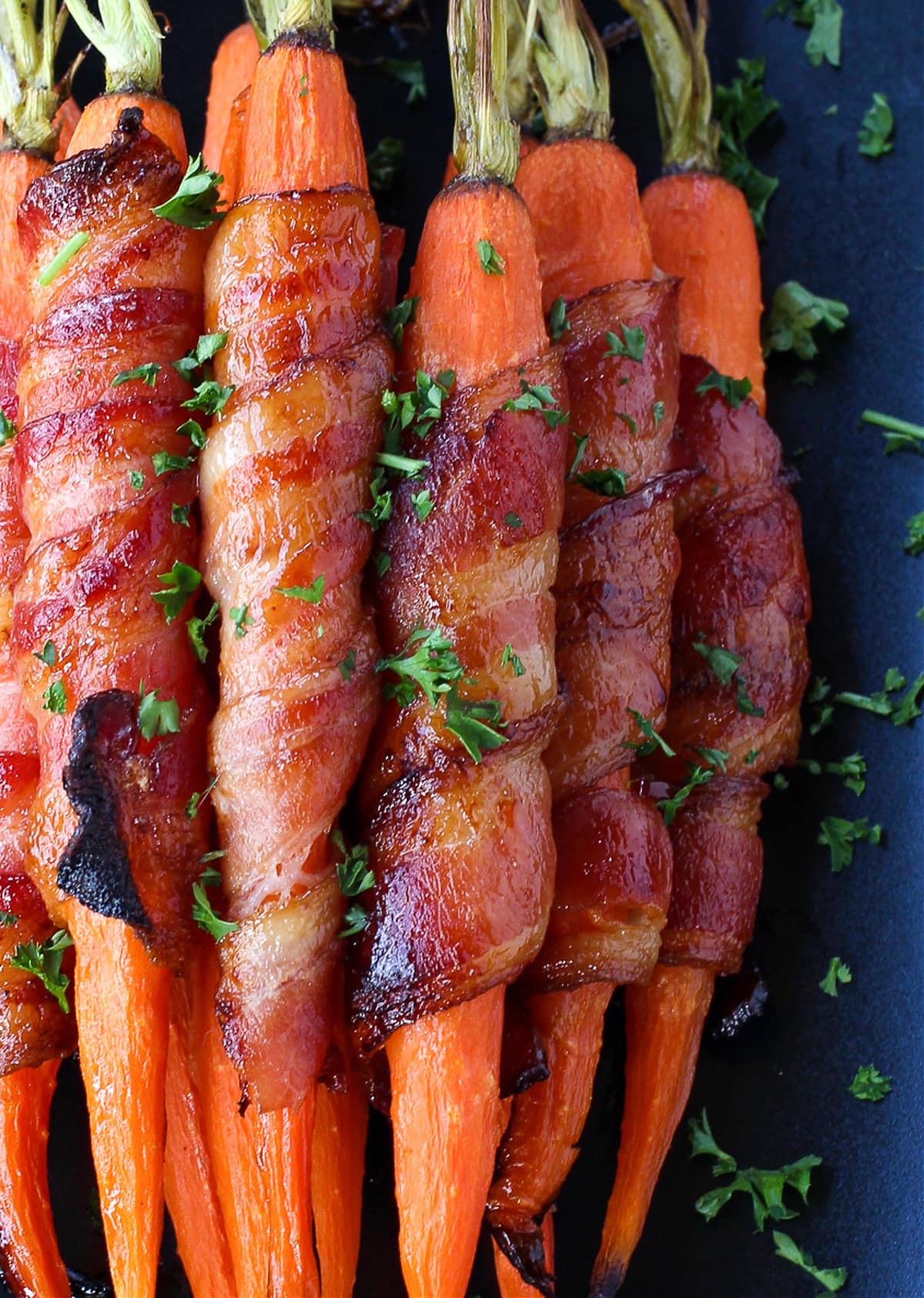 bacon wrapped carrots in platter with parsley
