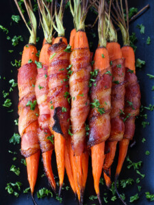 bacon wrapped carrots on black platter