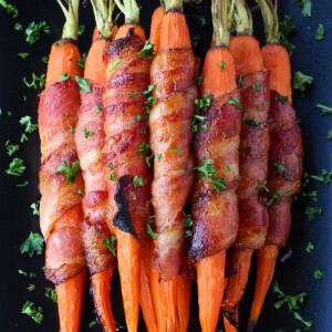 bacon wrapped carrots on black platter