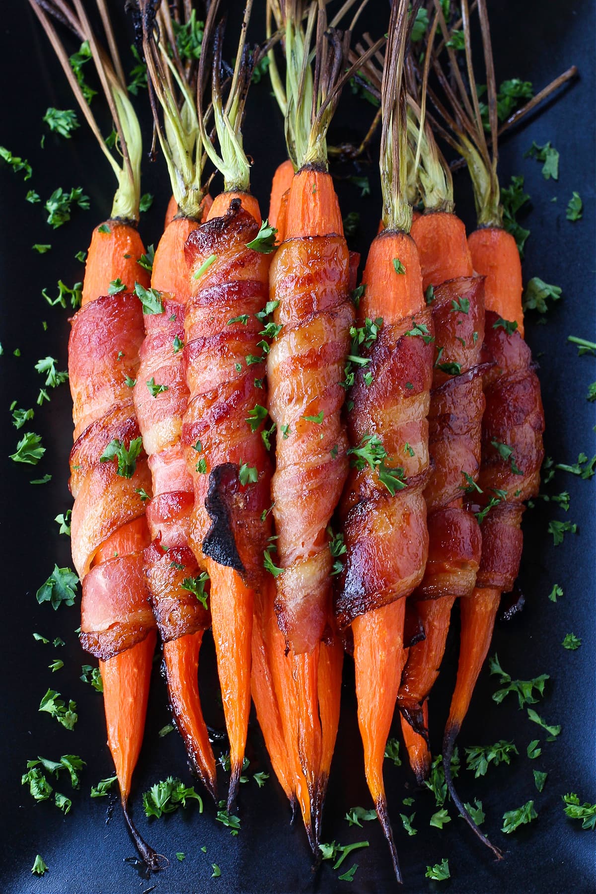 bacon wrapped carrots on black platter