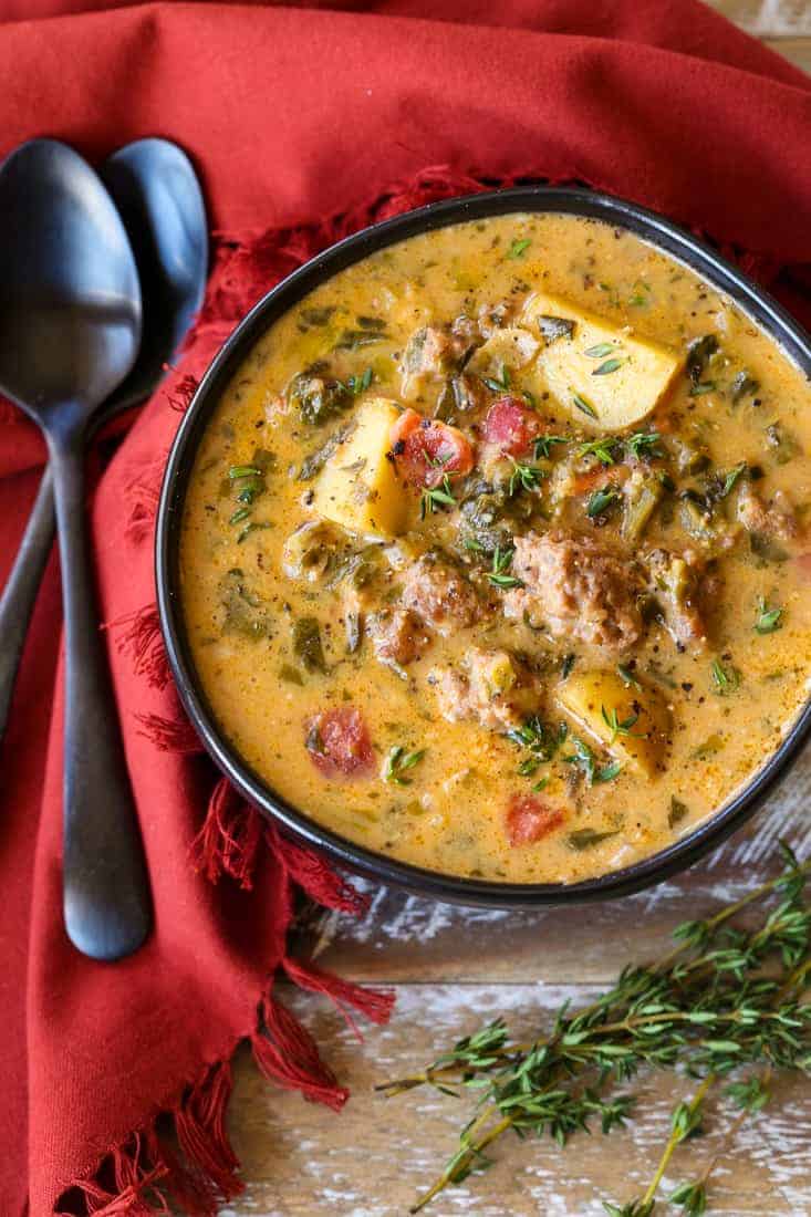 potato soup with italian sausage in a black bowl