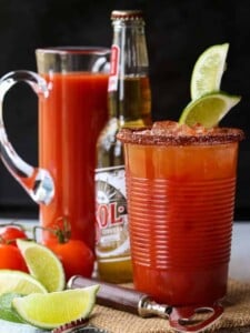 Michelada cocktail with a beer and a pitcher in the background