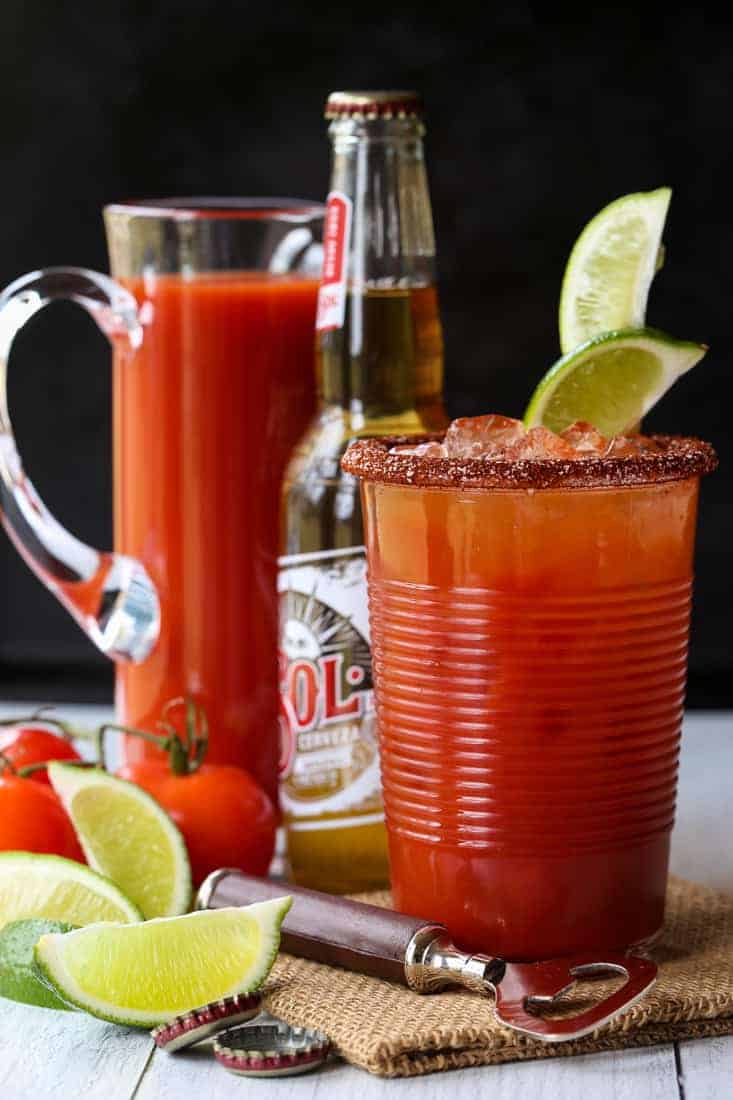 Michelada cocktail with a beer and a pitcher in the background