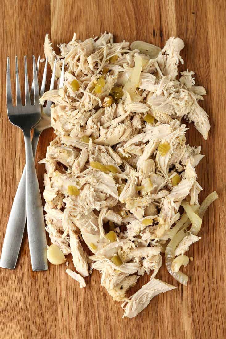 Slow Cooker Mexican Chicken is so full of flavor with just a few ingredients! Use this chicken for tacos, burritos, nachos, salads and more! Slow cooker Mexican Chicken on a board with forks