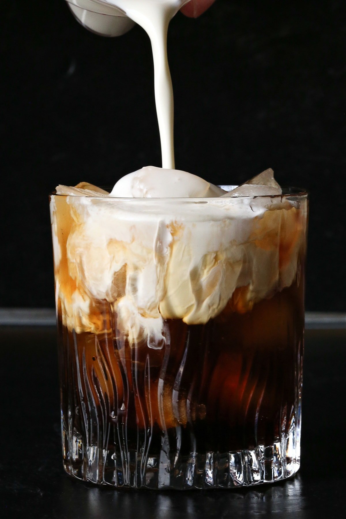 A classic White Russian recipe is a favorite with coffee lovers. A creamy, coffee-infused cocktail that's wonderful as an after dinner drink. cream being poured into white russian drink