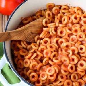 Spaghettios in a white pot with a wooden spoon