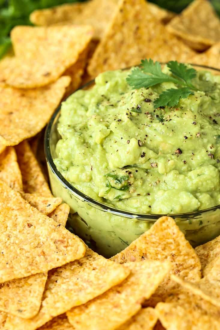 Easy Guacamole recipe in a bowl with fresh pepper and chips