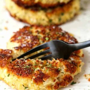 potato cakes on a plate with a black fork