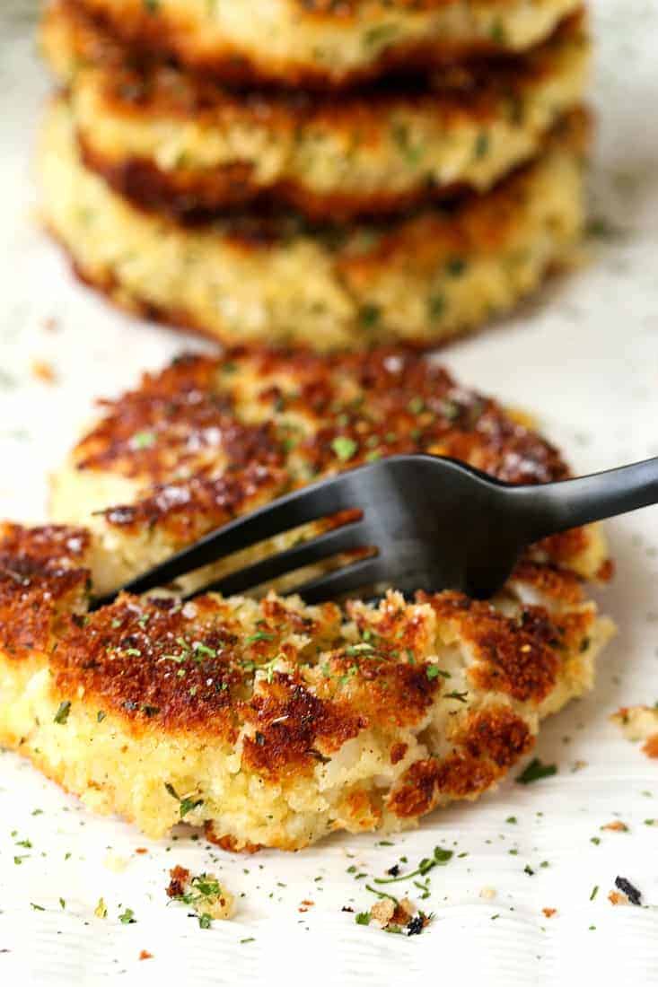 Mashed potato cakes on a plate with a black fork