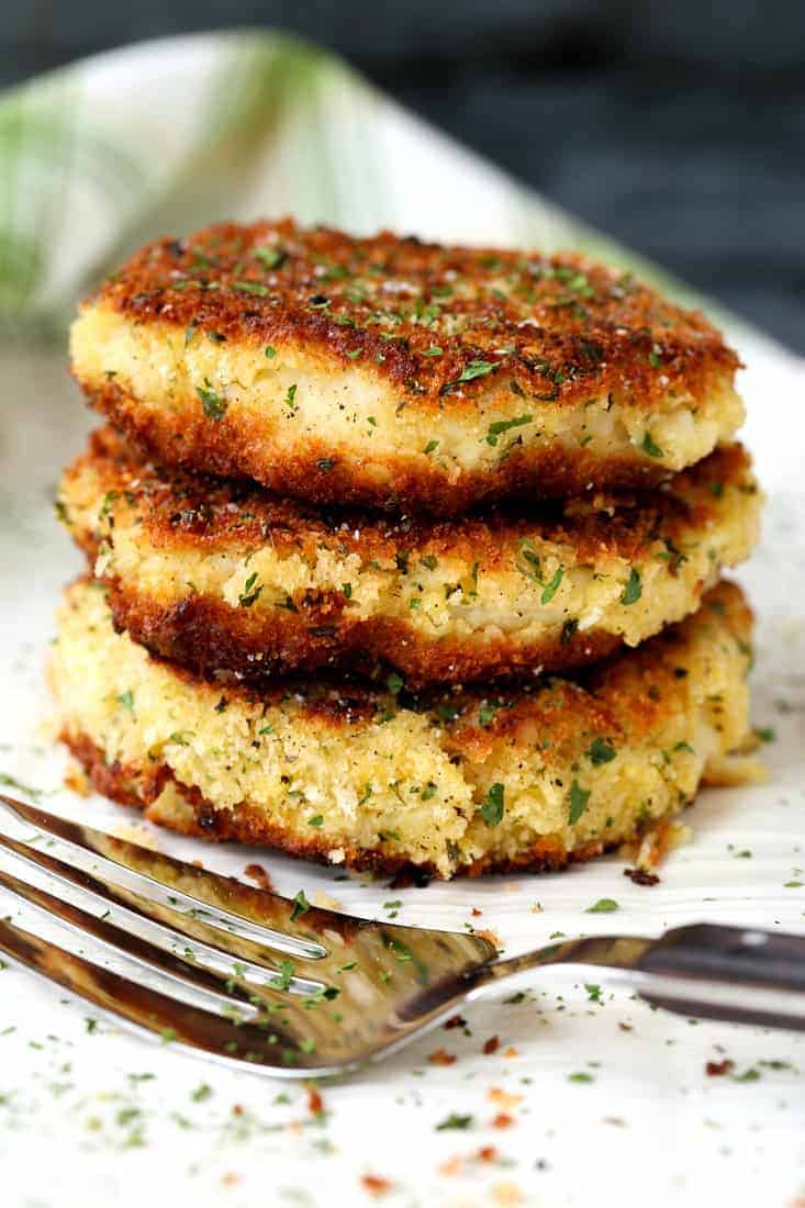 Mashed Potato Cakes stacked on a white platter with fork