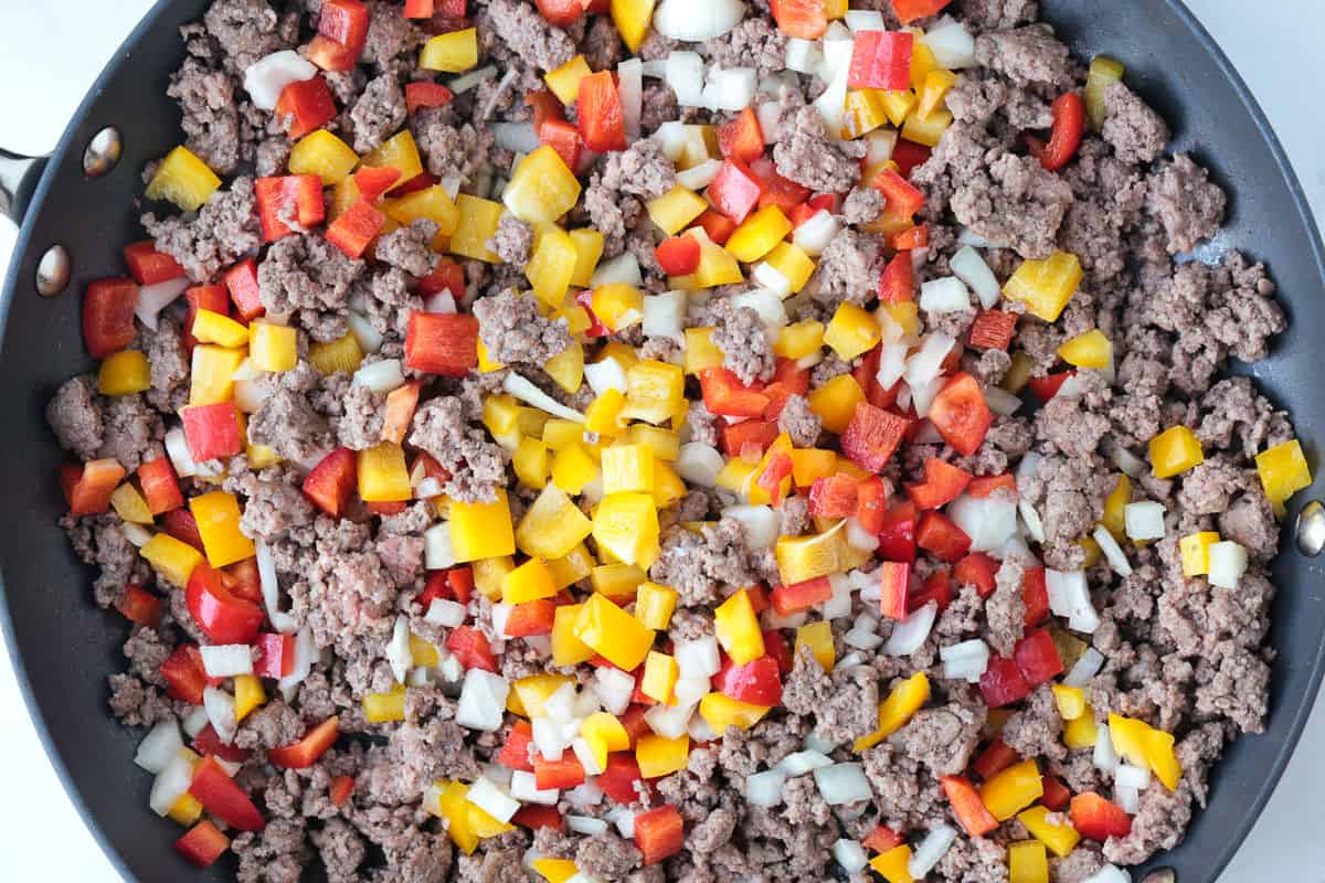 Philly Cheesesteak Fried Rice is the ultimate, comfort food dinner! Ground beef, peppers and gooey cheese make this fried rice irresistible! ground beef, peppers and onions in skillet