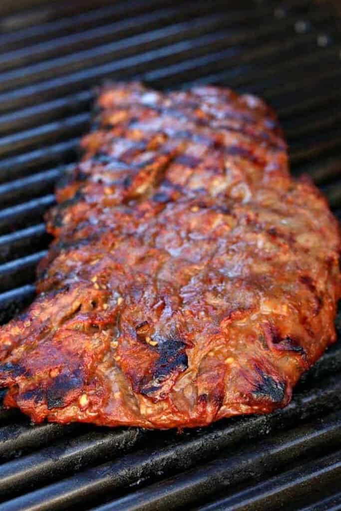 Our famous Whiskey Steak Marinade! Let this marinade work overnight for a tender, flavorful steak with a perfect caramelized crust! marinated steak on grill