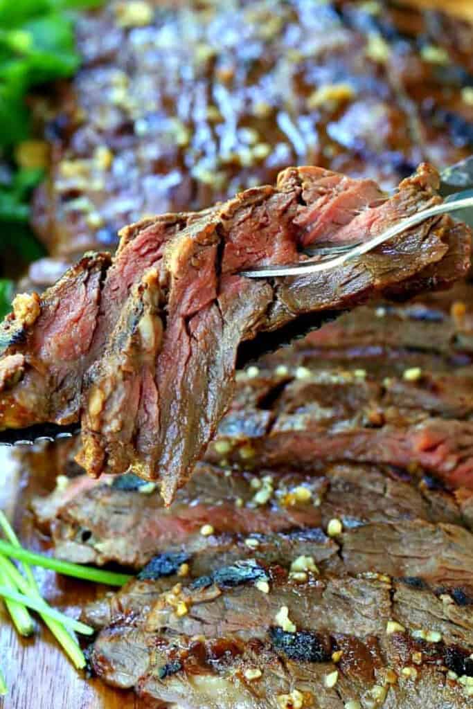 Our famous Whiskey Steak Marinade! Let this marinade work overnight for a tender, flavorful steak with a perfect caramelized crust! sliced steak on serving fork