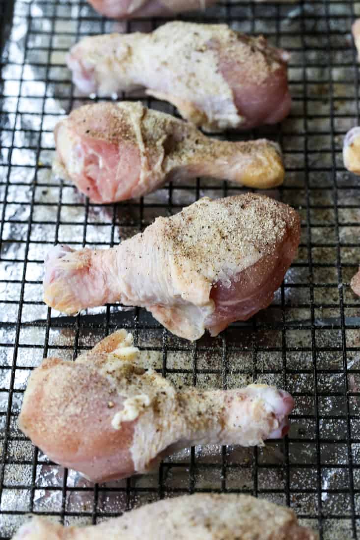chicken legs with seasoning on a baking rack