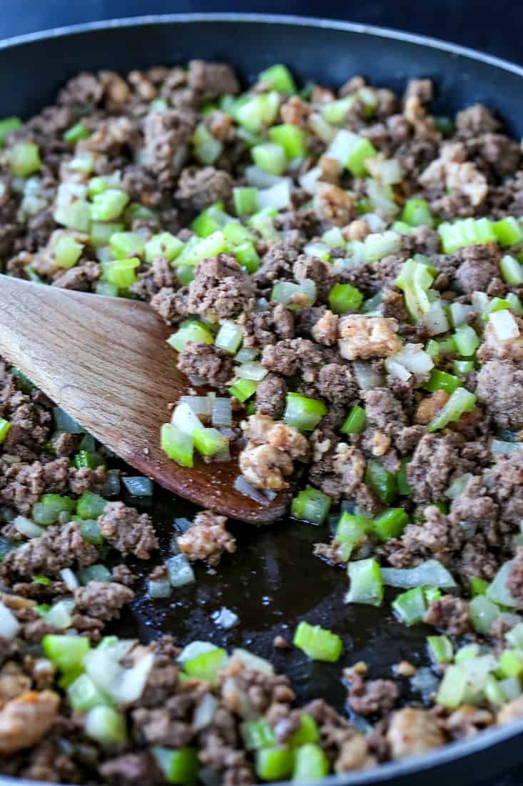 Ground beef and Italian sausage browning in a skillet with celery