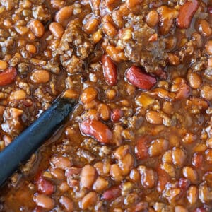 slow cooker baked beans with a spoon