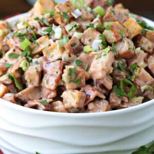 bbq potato salad in a white bowl from the side