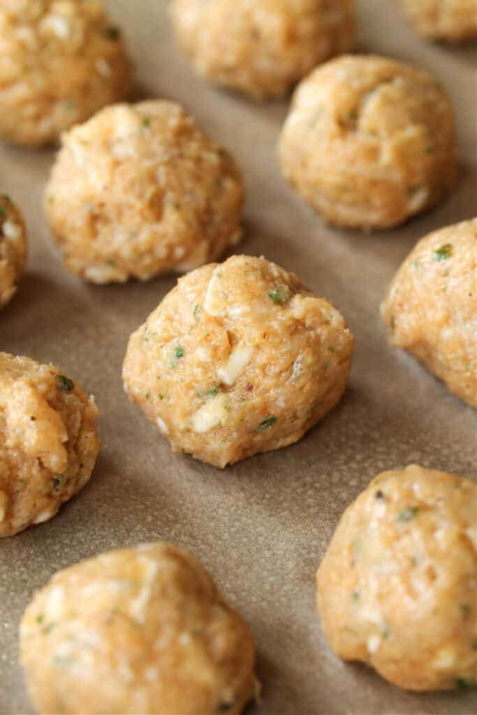 raw chicken meatballs on a baking sheet
