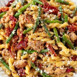 pasta with sausage and asparagus in white bowl