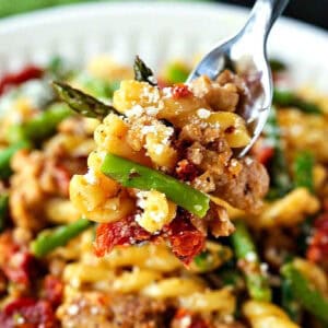 pasta with sausage and asparagus on a fork