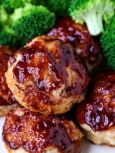 mini meatloaf muffins on a plate with broccoli