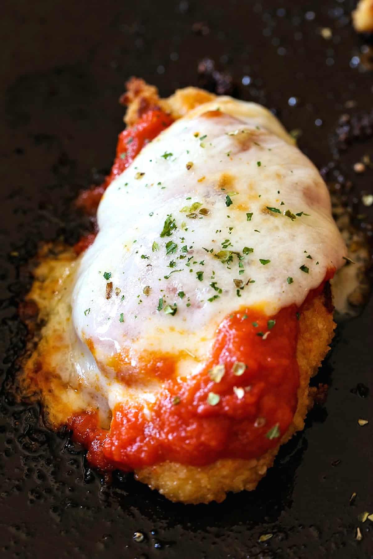 single chicken tenderloin with melted cheese and sauce
