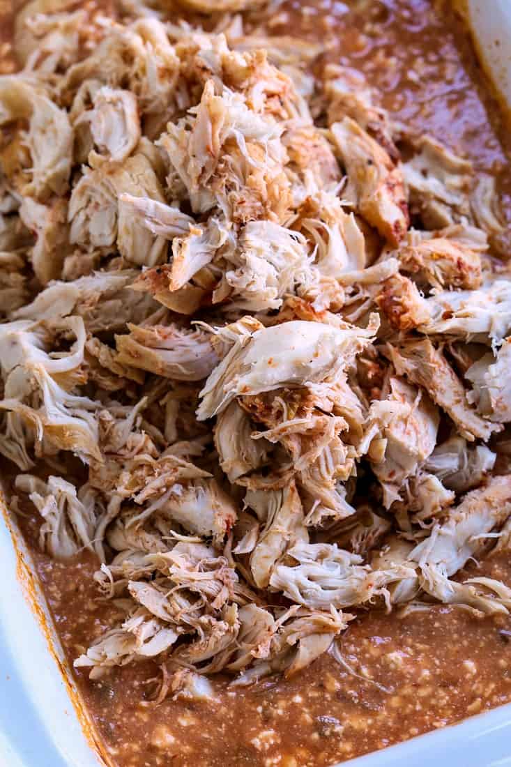 Shredded chicken with chipotle sauce piled in a slow cooker.