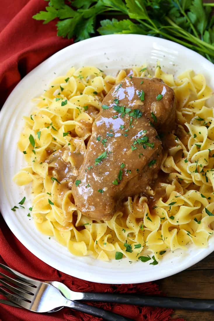 Crock Pot Smothered Pork Chops turn out fork tender, simmered in a delicious brown gravy! Serve with egg noodles, fries or mashed potatoes! pork chops covered with brown gravy