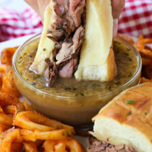 roast beef sandwich being dipped into au jus