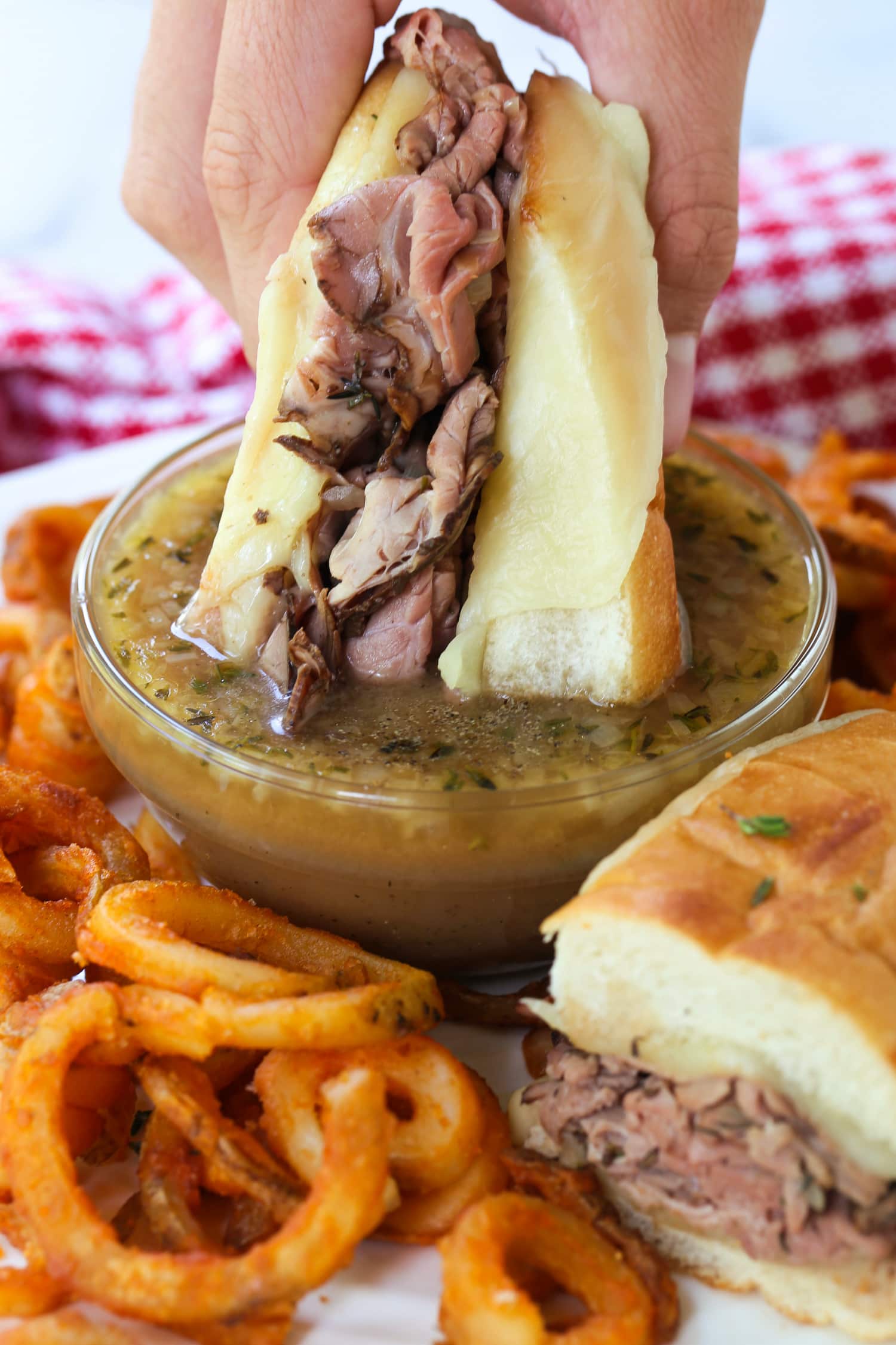 roast beef sandwich being dipped into au jus