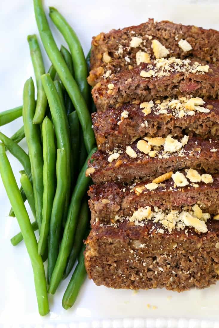 Ground beef meatloaf recipe on plate with green beans